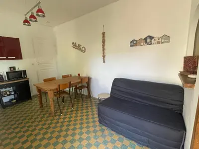 a living room with a table and a couch at Du côté de chez nous in Cuxac-dʼAude