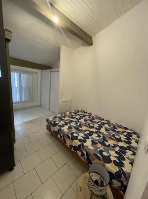 a bedroom with a bed in the corner of a room at Appart T2 au Vernet d'Ariège avec jardin privatif in Le Vernet