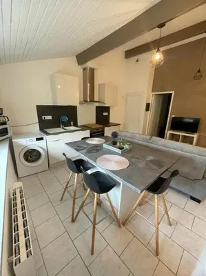 a kitchen with a table and chairs in it at Appart T2 au Vernet d'Ariège avec jardin privatif in Le Vernet