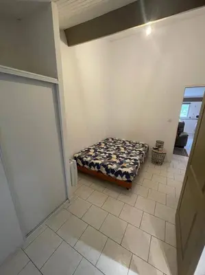 a bedroom with a bed in the corner of a room at Appart T2 au Vernet d'Ariège avec jardin privatif in Le Vernet