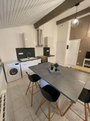 a kitchen with a table and chairs in a room at Appart T2 au Vernet d'Ariège avec jardin privatif in Le Vernet