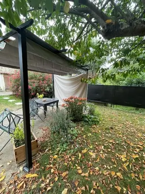 a gazebo with a table and a bench in a yard at Appart T2 au Vernet d'Ariège avec jardin privatif in Le Vernet