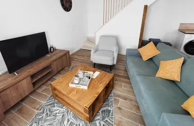 a living room with a couch and a tv at Les remparts de Caroline, au pied de La Cité. in Carcassonne
