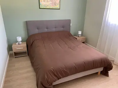 a bedroom with a large bed with two night stands at Chez ERIC in Villeneuve-du-Paréage