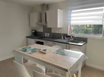 a kitchen with a table and chairs and a window at Chez ERIC in Villeneuve-du-Paréage
