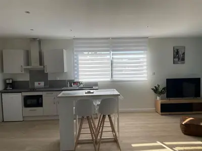 a kitchen with a table and two stools in a room at Chez ERIC in Villeneuve-du-Paréage