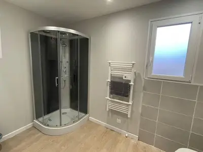 a glass shower in a bathroom with a window at Chez ERIC in Villeneuve-du-Paréage
