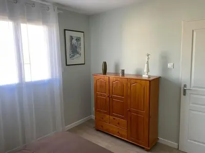 a room with a wooden cabinet and a window at Chez ERIC in Villeneuve-du-Paréage