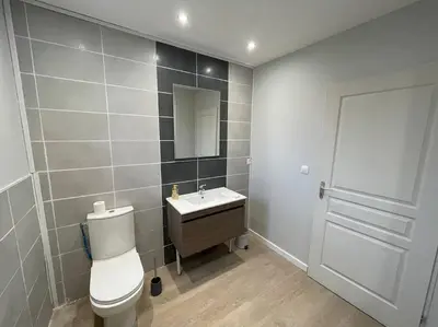 a bathroom with a toilet and a sink and a mirror at Chez ERIC in Villeneuve-du-Paréage