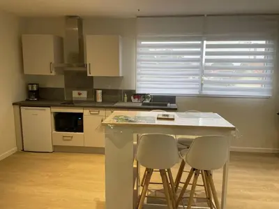 a kitchen with two bar stools and a counter top at Chez ERIC in Villeneuve-du-Paréage