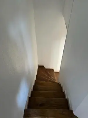 a staircase with wooden floors and a white wall at Marsanne cottage for 2 and 2 people in the heart of the vineyard in Badens