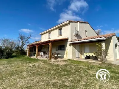 a large house with a large yard in front of it at Le joyaux d'ambre in La Pomarède