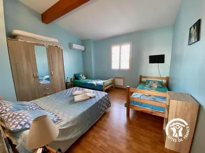 a bedroom with two beds and a lamp in it at Le joyaux d'ambre in La Pomarède