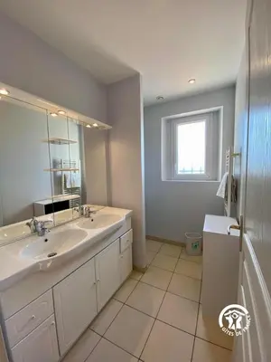 a white bathroom with a sink and a mirror at Le joyaux d'ambre in La Pomarède