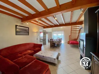 a living room with a red couch and a table at Le joyaux d'ambre in La Pomarède