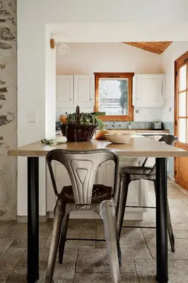 a kitchen with a table and chairs in a room at Domaine de Roquenégade - Piscine, sauna et bain nordique in Pradelles-en-Val