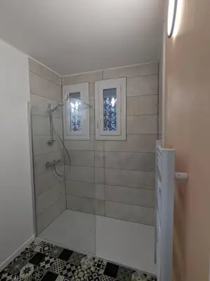 a bathroom with a shower with a glass door at Appartment - vue imprenable sur la cité médiévale - Parking gratuit - Climatisé in Carcassonne