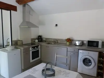 a kitchen with a washing machine and a dishwasher at Haut de maison et piscine dans un domaine viticole in Montbrun-des-Corbières