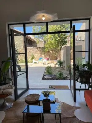 a living room with a door open to a patio at Grande Maison de Maitre contemporaine à 10 min de la mer et Piscine in Salles-d'Aude
