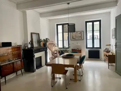 a living room with a table and chairs and a fireplace at Grande Maison de Maitre contemporaine à 10 min de la mer et Piscine in Salles-d'Aude