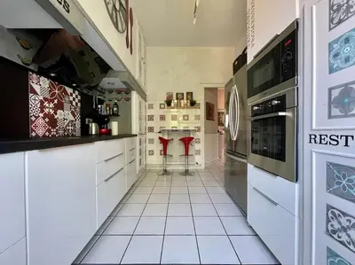 a kitchen with white cabinets and red stools in it at Le Balcon de Gambetta ※ in Carcassonne