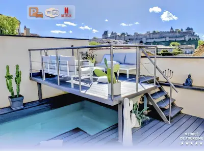 a balcony with a table and chairs on a roof at La Maison Blanche 5*, Piscine & vue Cité Médiévale in Carcassonne