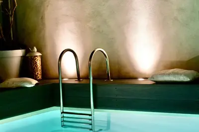 a bath tub with two faucets in a bathroom at La Maison Blanche 5*, Piscine & vue Cité Médiévale in Carcassonne