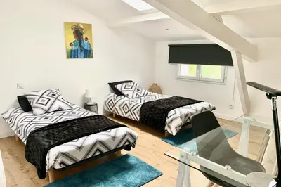 a bedroom with two beds and a glass table at La Maison Blanche 5*, Piscine & vue Cité Médiévale in Carcassonne