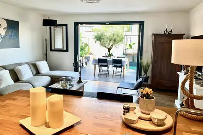 a living room with a couch and a table at La Maison Blanche 5*, Piscine & vue Cité Médiévale in Carcassonne