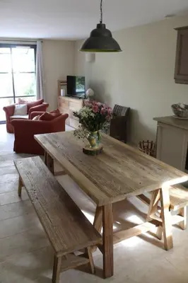 a wooden table and benches in a living room at Maison provençale en Corbières in Saint-Laurent-de-la-Cabrerisse