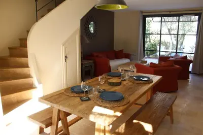 a living room with a wooden table with plates and glasses at Maison provençale en Corbières in Saint-Laurent-de-la-Cabrerisse