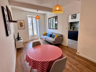 a living room with a table and a couch at Appartement Minervoise - Gare Carcassonne in Carcassonne