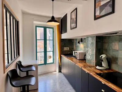 a kitchen with a counter and some chairs in it at Appartement Minervoise - Gare Carcassonne in Carcassonne