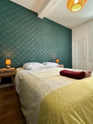 a bedroom with a bed and a table with two lamps at Appartement Minervoise - Gare Carcassonne in Carcassonne