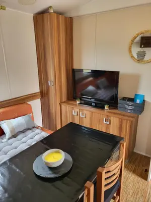 a living room with a table and a tv at Anthony MH 140 in Port-la-Nouvelle