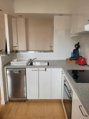 a kitchen with white cabinets and a stainless steel sink at Appartement Morgand in Narbonne