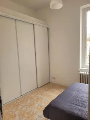 a bedroom with white wardrobes and a bed at Appartement Morgand in Narbonne