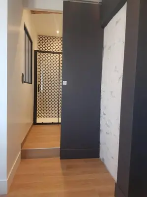 a hallway with a black wall and a wooden floor at Le Merlane - A 2 pas de la Cité & du centre ville in Carcassonne