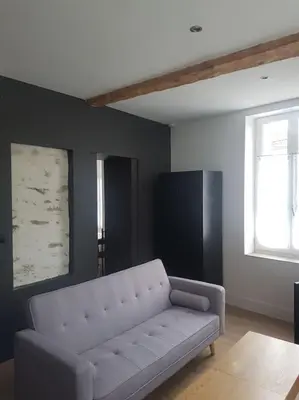 a living room with a white couch and a window at Le Merlane - A 2 pas de la Cité & du centre ville in Carcassonne