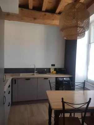 a kitchen with a table and a table and chairs at Le Merlane - A 2 pas de la Cité & du centre ville in Carcassonne