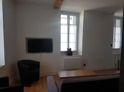 a living room with a flat screen tv on the wall at Le Merlane - A 2 pas de la Cité & du centre ville in Carcassonne