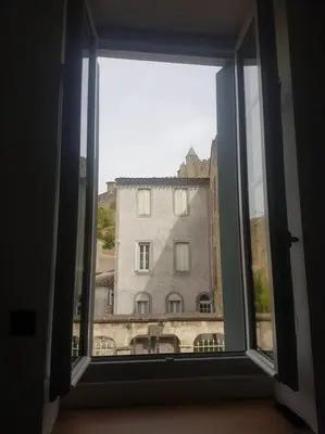 an open window with a view of a building at Le Merlane - A 2 pas de la Cité & du centre ville in Carcassonne