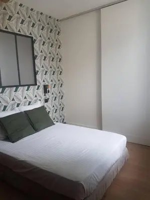 a bedroom with a large white bed with green pillows at Le Merlane - A 2 pas de la Cité & du centre ville in Carcassonne