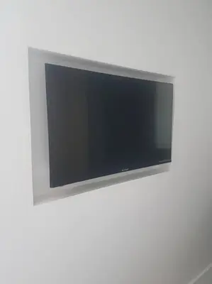 a flat screen tv hanging on a white wall at Le Merlane - A 2 pas de la Cité & du centre ville in Carcassonne