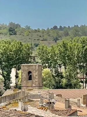 a small building with a bell tower on a roof at Le Petit Château de Tournissan in Tournissan