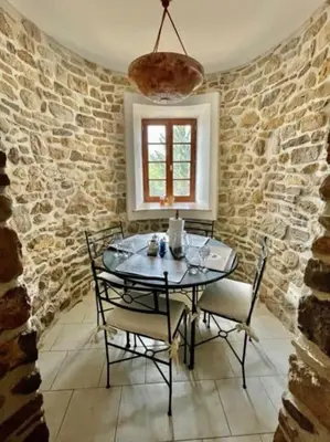 a dining room with a glass table and chairs at Le Petit Château de Tournissan in Tournissan