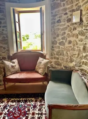 a living room with a bench and a window at Le Petit Château de Tournissan in Tournissan
