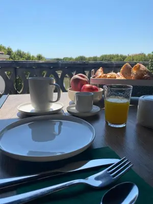 a table with a plate of food and a glass of orange juice at Maison d’hôtes Le 1853 in Narbonne