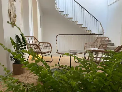 a patio with chairs and a table and stairs at Maison d’hôtes Le 1853 in Narbonne