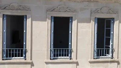 three windows on the side of a building at Maison d’hôtes Le 1853 in Narbonne